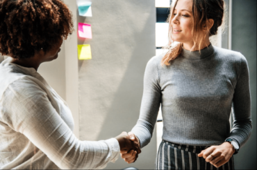 A woman giving handshake to other woman